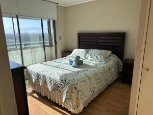 a bedroom with a bed with a stuffed animal on it at Departamento en Santiago cercano a aeropuerto y metro in Santiago