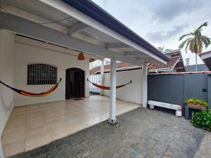 a patio with hammocks on the side of a house at Casa Térrea Pet Friendly 8 Pessoas Ubatuba in Ubatuba