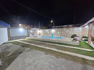 a backyard with a swimming pool at night at casa de Praia in Goiana +3 photos