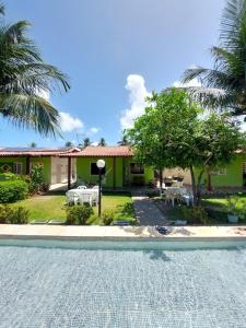 a resort with a swimming pool and a house at Casa do Sossego in Itamaracá