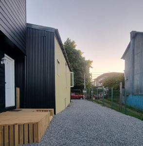 a building with a gravel sidewalk next to a building at cabaña centrica con vista al rio in Valdivia