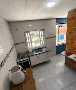 eine große Küche mit Spüle und Herd in der Unterkunft Chalé Completo Com Linda Vista para o Mar de Ilhabela in Ilhabela