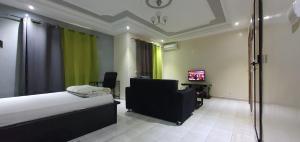 a bedroom with a bed and a chair and a television at RESIDENCE ADSL Studio BOUYGUES in Dakar