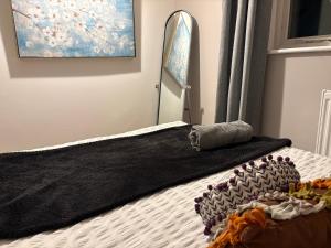 ein Bett mit einer schwarzen Decke darüber in der Unterkunft Beautiful Rooms near Hampton Court in Molesey