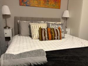 ein Bett mit Kissen und einer Decke darauf in der Unterkunft Beautiful Rooms near Hampton Court in Molesey