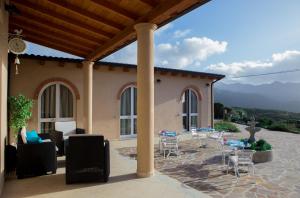 a patio with chairs and tables in front of a house at B&B Raggio di Sole in Fluminimaggiore