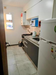 Una cocina con un refrigerador blanco y un fregadero. en Excelente departamento barrio constituyentes, en Santa Fe