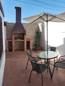 a patio with a table with an umbrella and a stove at Casablanca Ovalle in Limarí