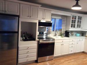 a kitchen with white cabinets and a stove top oven at Quiet Lake View Firepit, Deck, BBQ, 3 Winery Walk in Essex