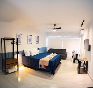 アグアス・デ・リンドイアにあるLoft das Águas, Vista para as Montanhas, 6のベッドルーム(青いベッド1台、ソファ付)