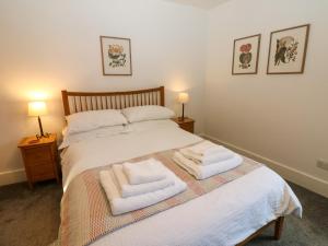 a bedroom with a bed with towels on it at Bay Tree Cottage in Richmond