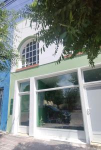 プエルト・マドリンにあるDepartamento céntricoの大きな窓があり、車が置いてある建物