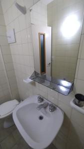 プエルト・マドリンにあるDepartamento céntricoの洗面台とトイレを備えた白いバスルーム +9枚の写真