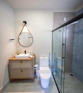 アグアス・デ・リンドイアにあるLoft das Águas, Vista para as Montanhas, 6のトイレ、洗面台、鏡のあるバスルーム