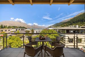 a balcony with a table and chairs and mountains at Chambers City Centre Penthouse in Queenstown