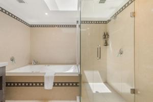 a bathroom with a bath tub and a shower at Chambers City Centre Penthouse in Queenstown +11 photos