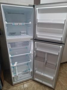 Un refrigerador vacío con la puerta abierta en una cocina. en Paz, en Peruíbe