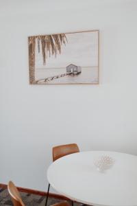 une table blanche avec des chaises et une photo d'une maison dans l'établissement Serene Stay Near Perth & Freo, à Bicton
