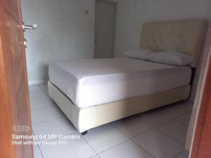 a white bed in a room with a white floor at Niti Guest House in Tegalan