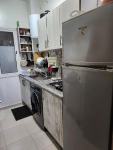 a kitchen with a stainless steel refrigerator and a stove at Comfortable apartment near the Airport in Marrakech