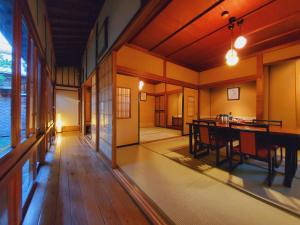 a room with a wooden table and a dining room at Tokiwakan in Shimonita