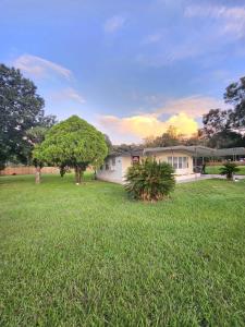 a house in a yard with a green field at Country Home in the City with an Acre of Land in Zephyrhills +37 photos