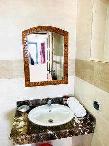 a bathroom with a sink and a mirror at La terasse vue sur mer uniquement les familles in Oualidia +43 photos