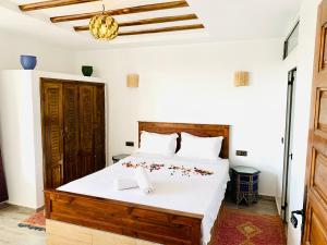 a bedroom with a large bed with white sheets at La terasse vue sur mer uniquement les familles in Oualidia