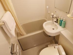 Un baño pequeño con lavabo e inodoro. en Hotel Route-Inn Yokote Inter, en Yokote 28 fotos más