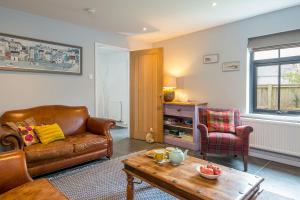 ein Wohnzimmer mit einem Ledersofa und einem Couchtisch in der Unterkunft Bwthyn Clyd in Haverfordwest