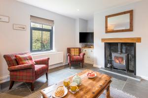 ein Wohnzimmer mit Kamin und Tisch in der Unterkunft Bwthyn Clyd in Haverfordwest