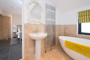 ein Badezimmer mit Badewanne und Waschbecken in der Unterkunft Bwthyn Clyd in Haverfordwest + 30 Fotos