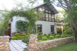 een huis met een stenen muur en een balkon bij Aan De Vliet Guest House in Stellenbosch