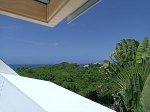 a view from the balcony of a house with trees at Chez Madeline in Le Gosier
