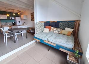 a couch in a room with a kitchen and a table at Chez Madeline in Le Gosier