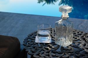 a glass bottle and a glass of water on a table at Rivadeneyra Hotel Boutique in Iguala de la Independencia