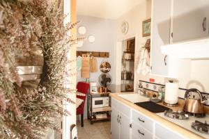 a kitchen with white cabinets and a christmas tree at 1 BR Orchard Cottage - Gateway to Two National Parks! in Visalia +13 photos