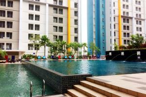 a swimming pool in a city with tall buildings at Cozy Living Studio at Paramount Skyline Apartment By Travelio in Tangerang
