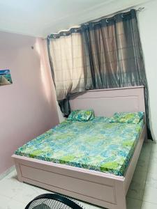 a small bed in a room with a curtain at West Side Résidence in Dakar