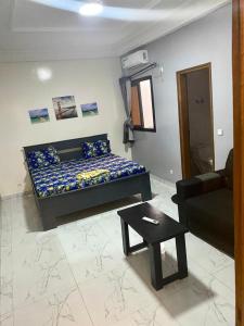 a room with a bed and a couch and a table at West Side Résidence in Dakar