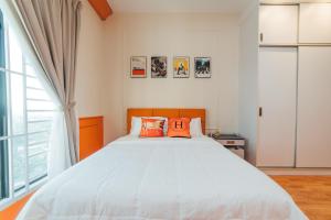 une chambre avec un grand lit avec des oreillers orange dans l'établissement Platino Hermès Palette 3BR 6pax nr Paradigm mall by Our Stay, à Johor Bahru 62 autres photos