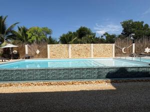 a swimming pool in front of a brick wall at Forest Condominio in Coveñas