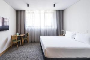 a hotel room with a bed and a table at Mary MacKillop Place in Sydney