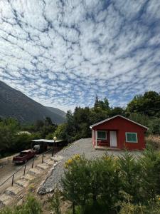 a small red house sitting on top of a pile of gravel at Parcela Santa Elena, Cabaña1 in San José de Maipo