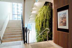 a staircase with a large green plant on the wall at Mary MacKillop Place in Sydney +39 photos