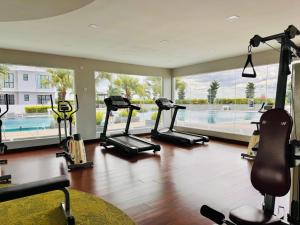 une salle de sport avec plusieurs tapis de course et une piscine dans l'établissement Platino Hermès Palette 3BR 6pax nr Paradigm mall by Our Stay, à Johor Bahru