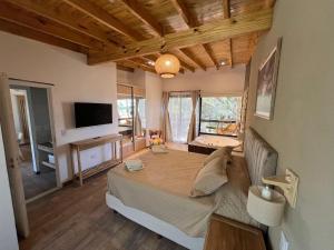 Santa TeresitaにあるBrisas del Jaguel Depto 6の大きなベッドとテレビのある寝室