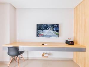 a desk in a room with a chair at Homey and Minimalist Studio at Patraland Amarta Apartment By Travelio in Kejayan