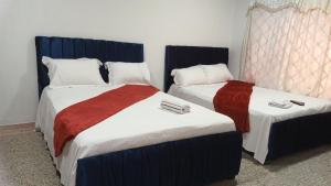 deux lits dans une chambre d'hôtel avec des serviettes dessus dans l'établissement Prado alto inn, à Barranquilla