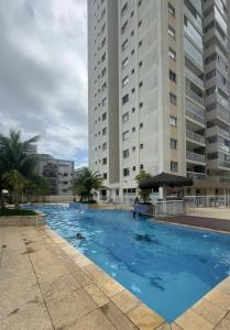 una grande piscina di fronte a due edifici alti di Cond Twice Guaruja Sp a Guarujá